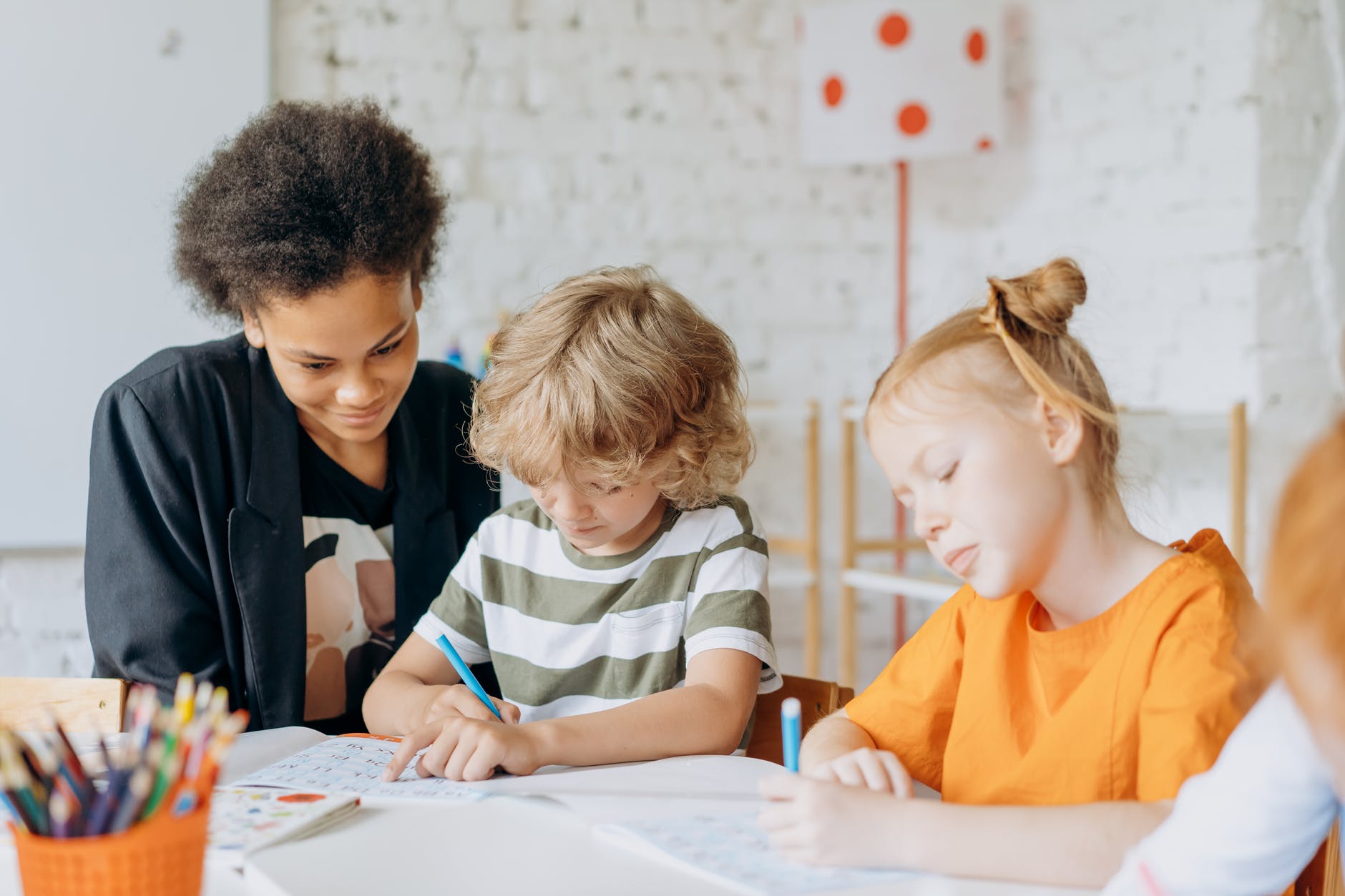 teacher supervises young students taking an assessment